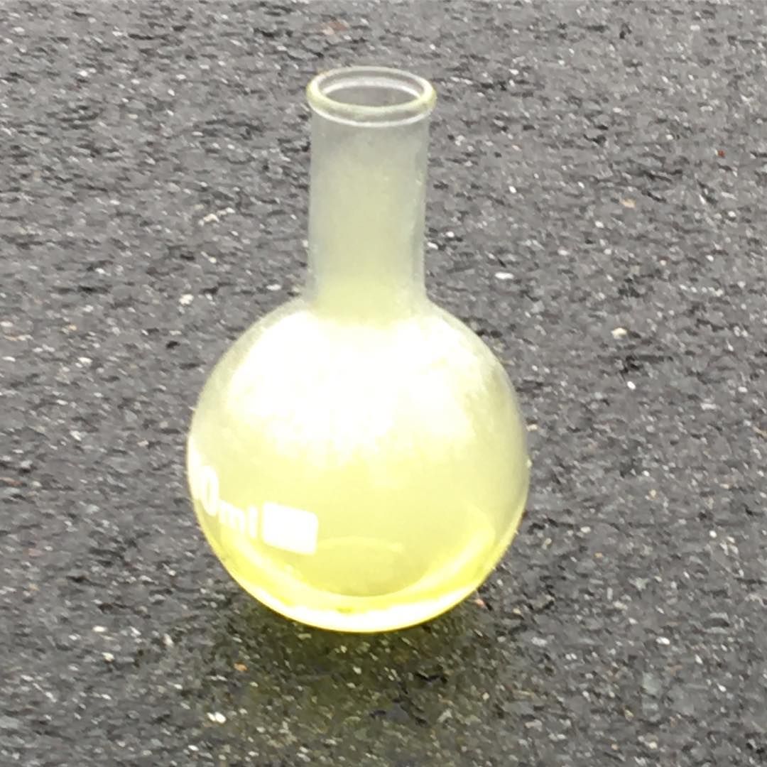 A round glass flask filled with pale yellow-green chlorine gas